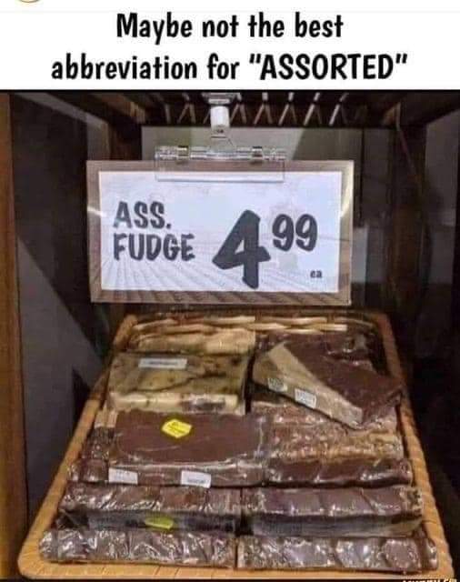 An image of a sign that reads 'Ass fudge' placed in front of a plate of various fudge flavors. The meme suggests that using the abbreviation 'ASSORTED' for the fudge may not have been the best idea. The humorous meme is a play on words and is sure to bring a smile to your face.